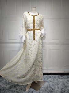 Detail der weißen Abaya mit Goldfoliendruck und elegantem Federbesatz an den Ärmeln