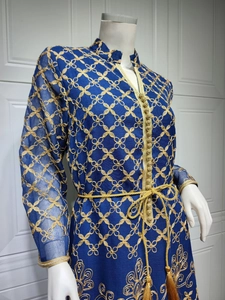 Dettaglio di abito blu scuro con ricamo a catena dorato e cintura intrecciata con nappe