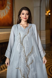 Detailed close-up of light grey kaftan dress featuring elegant gold sequin embroidery