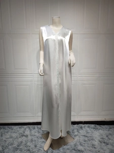 Detailed view of white satin kaftan with silver embroidery and V-neckline texture