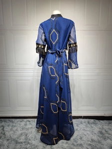 Detail of navy caftan with gold geometric embroidery and tassel fringe on sleeves