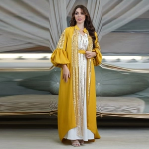 Close-up of yellow puff sleeve abaya with golden sequin embroidery and white inner dress