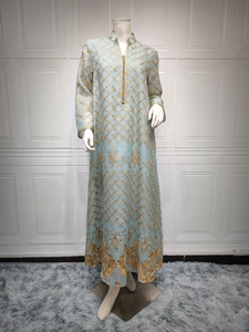 Dettaglio dell'abito kaftan azzurro con ricami floreali dorati e colletto alla coreana a bottoni