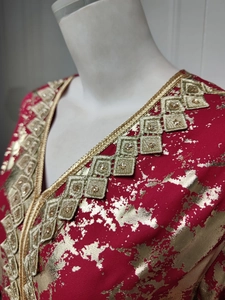 Detail of exotic red chiffon dress with gold foil patterns and embroidered collar