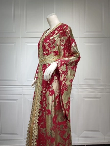 Detail of red chiffon kaftan dress with gold foil print and intricate embroidery