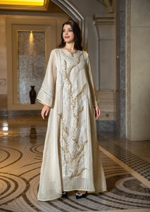 Elegant beige long sleeve maxi dress featuring intricate gold and silver sequin leaf embroidery