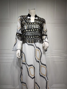 Detail of evening dress featuring black sequins, gold coin pendants and ethnic embroidery