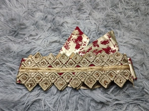 Macro detail of red chiffon dress with gold embroidery and sparkling sequins
