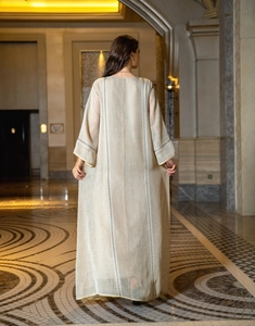 Detailed back view of a summer beige linen-textured plus size kaftan dress with embroidery
