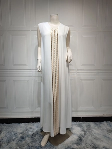 Detail of vertical golden sequin stripes on white V-neck maxi dress fabric