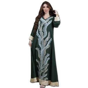 Détail de la broderie à paillettes argentées sur abaya vert foncé avec bord doré