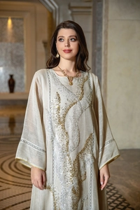 Close-up of elegant beige kaftan dress with intricate gold and silver sequin embroidery
