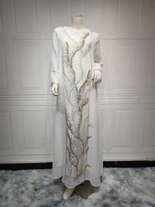 Detail of white maxi dress featuring elegant gold and silver sequin embroidery