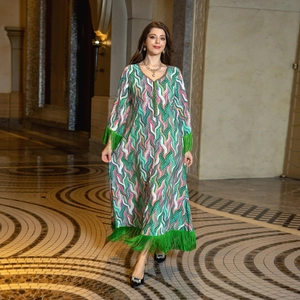 Detail of bohemian long sleeve dress with colorful wave print and green fringe tassels