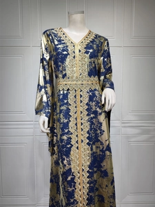 Close-up of gold bronzing pattern and geometric embroidery on dark blue chiffon dress