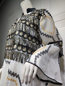 Detailed embroidery with black sequins and golden fringe on elegant evening gown