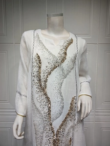 Detailed view of white summer tunic dress with gold and silver sequin embellishments