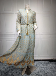 Dettaglio del vestito caftano azzurro con ricami dorati e cintura con nappine dorate