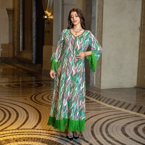 Macro shot of ethnic pattern long dress featuring colorful waves and green tassels