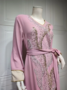 Détail d'un caftan rose avec broderies de paillettes complexes et liserés dorés