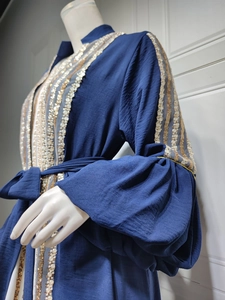 Detail of dark blue Abaya showing gold sequin embroidery and puffed sleeve texture