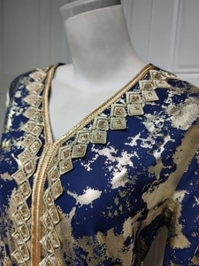 Detail of V-neckline embroidery and gold foil splatter print on navy chiffon dress