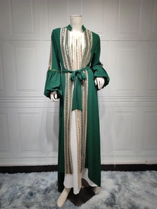 Detailed view of sequin embroidery and lantern sleeves on a dark green modest dress