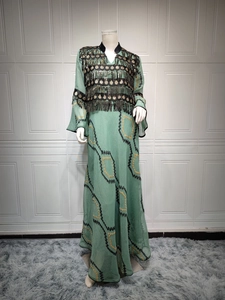 Close-up of evening dress featuring green chiffon, sequined embroidery, and metal tassels