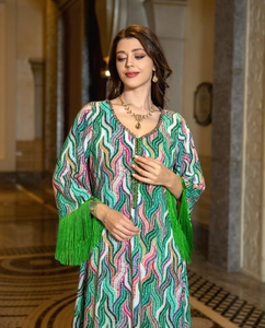 Detailed view of colorful kaftan dress featuring beaded V-neckline and green fringe sleeves