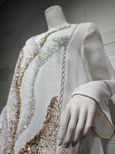 Detail of white plus size pullover dress with gold and silver sequin embellishments