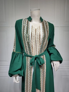 Close-up of golden sequin embroidery and stripe details on a green lantern sleeve abaya