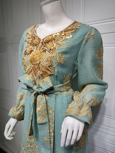 Close-up of golden sequins and ethnic embroidery on mint green party dress collar