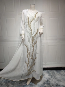 Detailed view of gold and silver sequin embroidery on a white maxi dress.