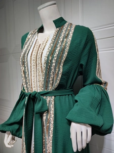Detail of green kaftan with intricate gold sequin embroidery and puff lantern sleeves