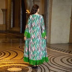 Detail of colorful wave print dress with green tassel fringe on sleeve and hem