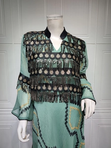 Close-up of mint green sequin fringe dress with gold disc embroidery and flared sleeves