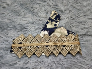 Macro detail of black and gold chiffon belt with intricate sequins and floral embroidery