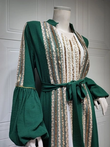Detail of sequin embroidery on dark green kaftan with white inner lining and gold trim