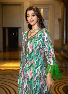 Detailed view of colorful wavy pattern knit dress with long green tassel sleeve cuffs