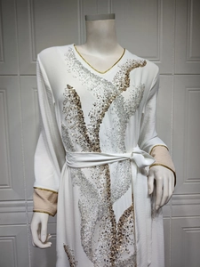 Détail de robe à manches longues, col en V, sequins dorés et poignets contrastés