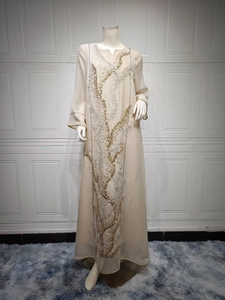 Close-up detail of intricate gold and silver sequin embroidery on champagne maxi dress.