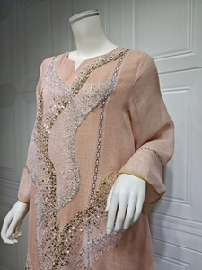 Close-up of peach pullover dress with gold and silver sequin embroidery details