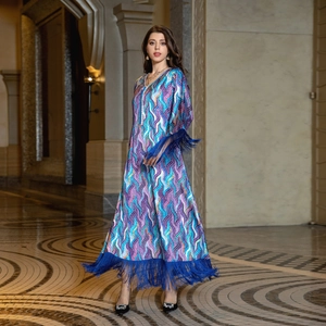 Detail of vibrant wavy print kaftan dress with electric blue fringe on the hem and sleeves