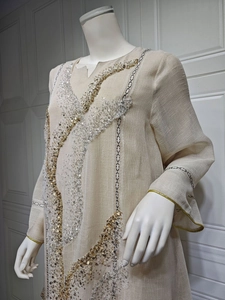 Detailed view of the sparkling sequin embroidery and fabric texture on beige tunic dress