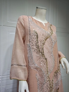 Detail of peach summer dress with elegant gold and silver sequin embroidery on front.