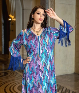 Detail of V-neckline with woven buttons and blue fringe cuffs on ethnic print dress