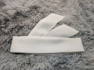 Détail de couches de tissu blanc brodé de paillettes sur un fond en fausse fourrure