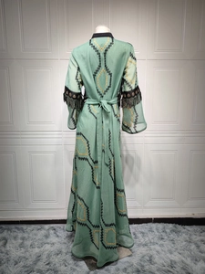Detail of light green Abaya featuring geometric embroidery and black tassel fringes on sleeves