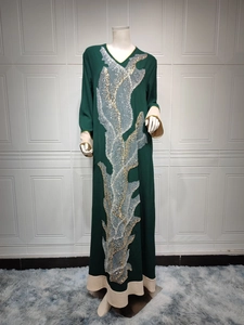 Détails de dentelle à paillettes dorées et argentées sur cette robe abaya vert foncé