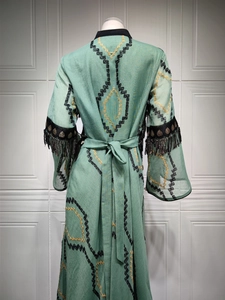 Detailed back view of mint green evening gown with black sequins and embroidery tassels